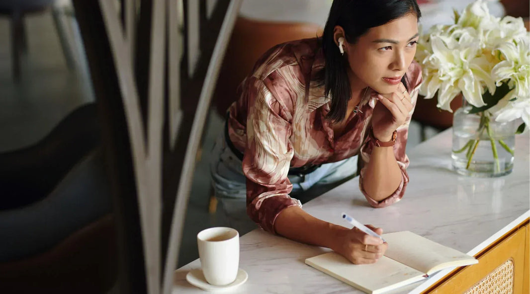 Woman writing on journal notebook