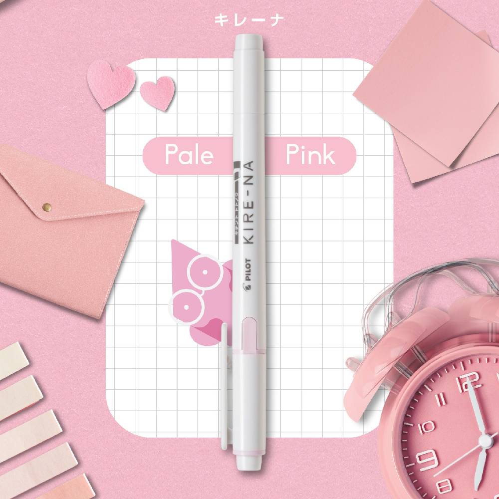 Pink pen on a grid notebook with stationery items on a pink background